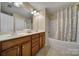 Bathroom with double sinks in a wood vanity, a large mirror, and a shower and tub combination at 920 Old Forester Ln, Charlotte, NC 28214