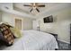 Bedroom with tray ceiling, bed with decorative pillows and a doorway into the attached bathroom at 920 Old Forester Ln, Charlotte, NC 28214