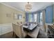 Elegant dining room with bay window, decorative lighting, and a table set for a formal dinner at 920 Old Forester Ln, Charlotte, NC 28214