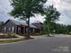 Community building with black siding, red trim, and manicured landscaping at 920 Old Forester Ln, Charlotte, NC 28214