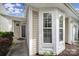 Home exterior featuring a front door with side window, a bay window and a paved walkway at 920 Old Forester Ln, Charlotte, NC 28214