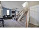Spacious living room with plush carpet, fireplace, ceiling fan, and staircase access to the upper level at 920 Old Forester Ln, Charlotte, NC 28214