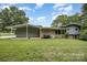 A home's exterior showing a large backyard with mature trees at 985 Needmore Rd, Woodleaf, NC 27054