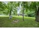 The back of a mid-century ranch-style home is nestled on a large lot shaded by mature trees at 985 Needmore Rd, Woodleaf, NC 27054