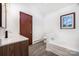 Bathroom featuring a white vanity, toilet, tub and modern fixtures, illuminated by natural light from a window at 985 Needmore Rd, Woodleaf, NC 27054