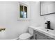 Well-lit bathroom with a modern vanity, toilet, and a window providing natural light at 985 Needmore Rd, Woodleaf, NC 27054