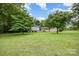 Single-story home with a spacious front yard, mature trees offering shade, and a well-maintained lawn at 985 Needmore Rd, Woodleaf, NC 27054