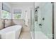 Bright bathroom featuring a soaking tub, glass shower, and modern fixtures at 1011 Bydeford Ct, Matthews, NC 28105