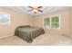 Bedroom with tan walls, a ceiling fan, two windows, and neutral carpeting at 115 Turner St, Lincolnton, NC 28092