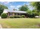 Charming brick ranch home featuring a well-manicured lawn and mature trees for added privacy at 115 Turner St, Lincolnton, NC 28092