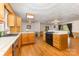 An open kitchen boasts wood cabinets, black appliances, and hardwood floors at 115 Turner St, Lincolnton, NC 28092