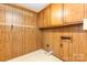 Laundry area includes brown cabinets and a hanging wire rack for storage at 115 Turner St, Lincolnton, NC 28092