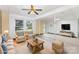 Living room area with large windows, a ceiling fan, and ample space for furniture at 115 Turner St, Lincolnton, NC 28092