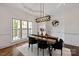 Dining room with dark hardwood floors, wainscoting, and contemporary lighting fixtures at 11841 Churchfield Ln, Charlotte, NC 28277