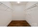 Empty walk-in closet featuring hardwood floors and wire shelving for optimal storage at 11841 Churchfield Ln, Charlotte, NC 28277