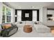 Spacious living room with white sofa, large windows, dark accent wall, and adjacent modern kitchen at 120 August Ln, Stallings, NC 28104