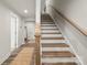 Inviting staircase with hardwood steps and white risers, complemented by a wooden handrail at 120 August Ln, Stallings, NC 28104