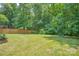 Large fenced-in backyard with lush green grass and mature trees, offering privacy and space at 1214 Northwoods Dr, Kings Mountain, NC 28086