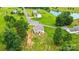 Aerial view of a home with garden plots and a lush green lawn, backing onto a serene pond in the distance at 124 Vintage Woods Ct, Shelby, NC 28150
