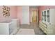 A cozy Bedroom with pink walls shows a white crib, dresser, and doorway to another room at 124 Vintage Woods Ct, Shelby, NC 28150