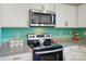 The modern kitchen has stainless steel appliances and light countertops and backsplash at 124 Vintage Woods Ct, Shelby, NC 28150