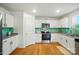 A well-lit kitchen featuring stainless steel appliances, granite countertops, and white cabinets at 124 Vintage Woods Ct, Shelby, NC 28150