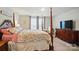 Spacious primary bedroom with a four-poster bed and a TV with plenty of natural light at 124 Vintage Woods Ct, Shelby, NC 28150