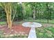 Backyard featuring a concrete fire pit with seating area, mature trees, and a wooden fence at 14904 Rosemary Way Dr, Huntersville, NC 28078