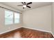 Cozy bedroom features neutral walls, hardwood floors, a ceiling fan, and a window offering natural light at 14904 Rosemary Way Dr, Huntersville, NC 28078