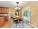 Dining room featuring decorative wallpaper, chandelier, hardwood floors and view to the enclosed porch at 14904 Rosemary Way Dr, Huntersville, NC 28078