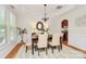 Elegant dining room features tray ceilings, a modern chandelier, and views into the bar area at 14904 Rosemary Way Dr, Huntersville, NC 28078