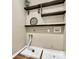 The laundry room includes built-in wooden shelves and connections for washer and dryer at 14904 Rosemary Way Dr, Huntersville, NC 28078