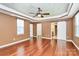 Spacious main bedroom with tray ceiling, barn door to bathroom, and warm hardwood floors throughout at 14904 Rosemary Way Dr, Huntersville, NC 28078