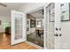 View of the sunroom from the living room, featuring a wooden table and black metal chairs, and access to the yard at 14904 Rosemary Way Dr, Huntersville, NC 28078