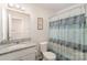 A well-lit bathroom featuring a granite countertop sink, toilet, and patterned shower curtain at 152 Grassy Meadow Ln, Statesville, NC 28625