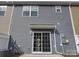 Exterior view of the rear of the house featuring gray siding and sliding glass doors to the backyard at 15239 Wrights Crossing Dr, Charlotte, NC 28278