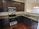 Modern kitchen showcasing granite countertops, stainless steel appliances, and dark wood cabinets at 15239 Wrights Crossing Dr, Charlotte, NC 28278