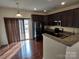 Stylish kitchen with stainless steel appliances, dark cabinets, granite counters, and patio access at 15239 Wrights Crossing Dr, Charlotte, NC 28278