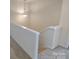 Upstairs hallway with a light neutral carpet and painted white railings at 15239 Wrights Crossing Dr, Charlotte, NC 28278