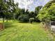 Spacious backyard featuring a wooden deck, a well-maintained lawn, and a fenced perimeter at 16 Cherry St, Albemarle, NC 28001