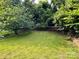 Spacious backyard featuring a well-maintained lawn and mature trees offering lots of shade at 16 Cherry St, Albemarle, NC 28001