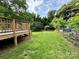 Spacious backyard featuring a wooden deck, a well-maintained lawn, and a fenced perimeter at 16 Cherry St, Albemarle, NC 28001