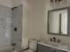 This bathroom features a modern sink, decorative mirror, and tiled shower at 16 Cherry St, Albemarle, NC 28001