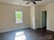 An empty bedroom featuring wood flooring, a ceiling fan and a window with natural light at 16 Cherry St, Albemarle, NC 28001