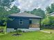 Charming home featuring a decorative wood porch, black siding, and a well-maintained front yard at 16 Cherry St, Albemarle, NC 28001