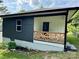 Home exterior showing a charming decorative wood porch and updated siding at 16 Cherry St, Albemarle, NC 28001