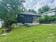 Charming home featuring a decorative wood porch, black siding, and a well-maintained front yard at 16 Cherry St, Albemarle, NC 28001