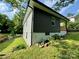 Green and grey home exterior featuring a grassy yard, stone landscaping and wooden porch at 16 Cherry St, Albemarle, NC 28001