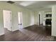 Spacious living room with dark wood floors and neutral walls with views to kitchen and entry at 16 Cherry St, Albemarle, NC 28001