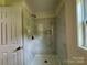 The tiled shower includes a built-in niche, new shower head, and bright lighting at 16 Cherry St, Albemarle, NC 28001